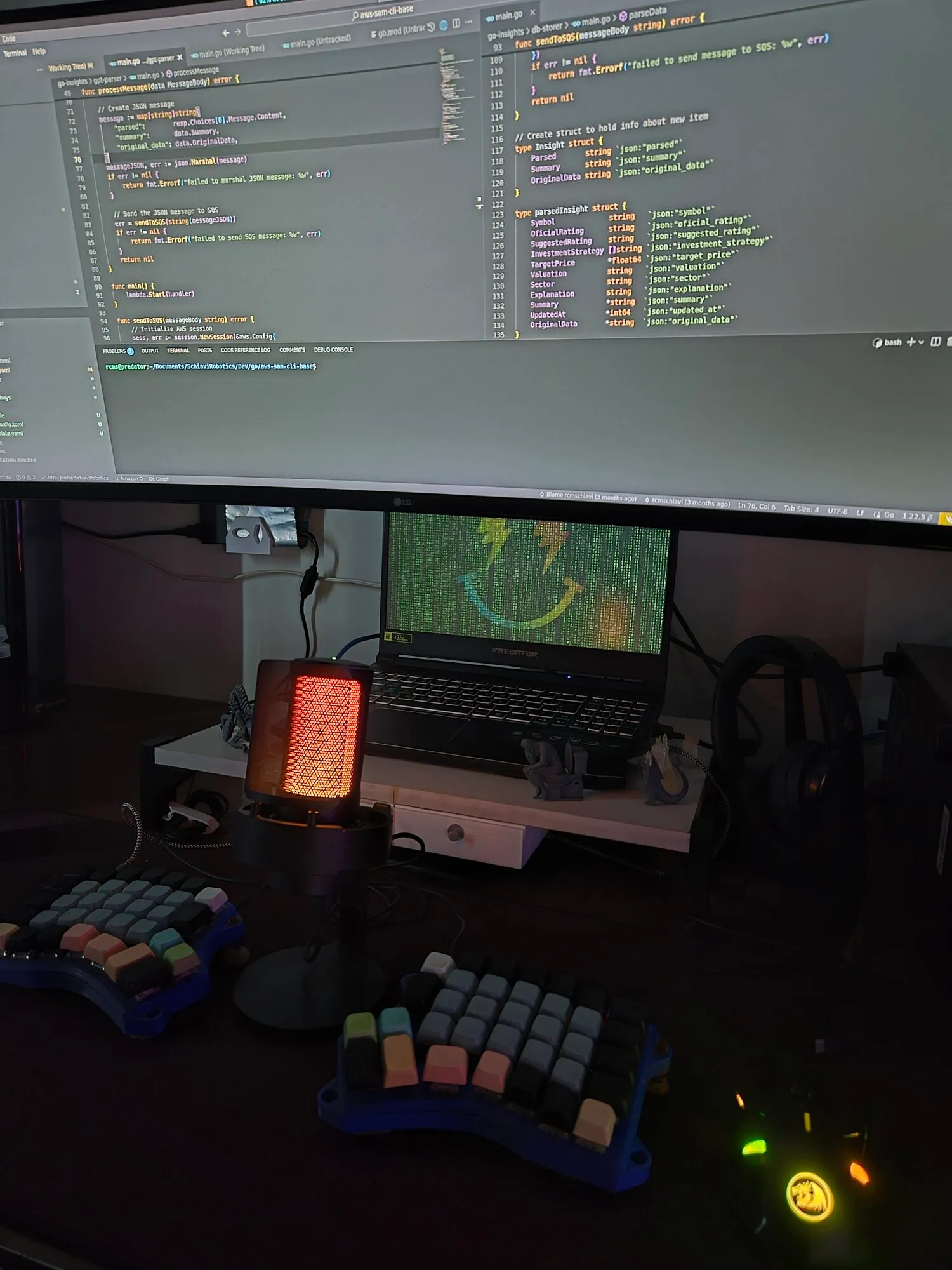 My workstation: dual monitors with code, split ergonomic keyboards, and a microphone